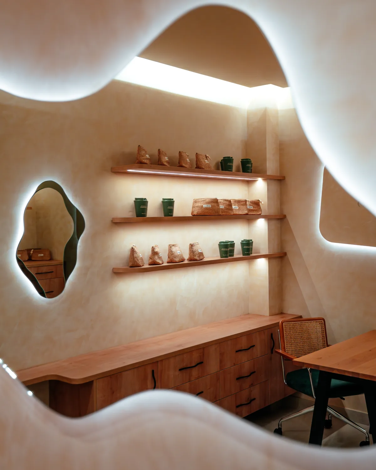 Espejo orgánico y estanterías de roble con productos de cosmética